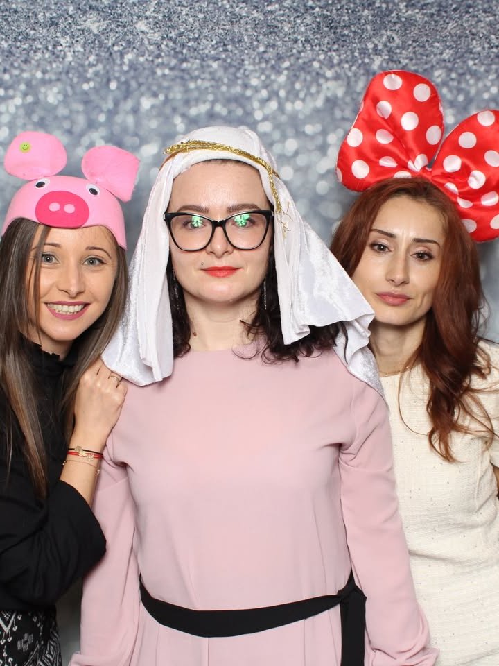 Colegi cu accesorii amuzante în cabina foto la o petrecere corporate