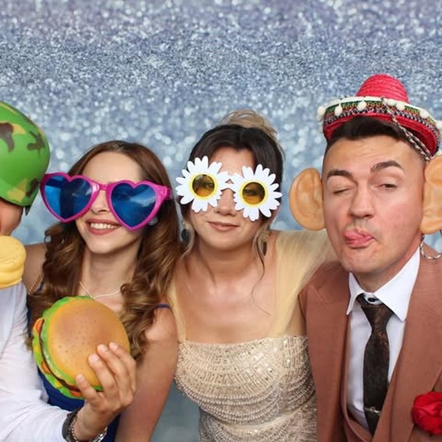 Invitați cu accesorii amuzante în cabina foto, fundal argintiu